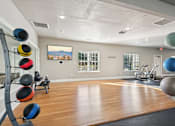 Thumbnail 50 of 70 - A gym with a wooden floor and a large mirror on the wall.