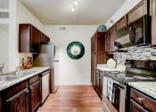 Thumbnail 5 of 42 - a kitchen with dark wood cabinets and white countertops