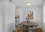 Thumbnail 6 of 26 - A dining room with a table and chairs.