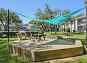 Thumbnail 38 of 47 - A concrete structure with a table and chairs under a blue tarp.