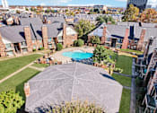 Thumbnail 28 of 35 - A large outdoor swimming pool surrounded by a shaded area and a grassy lawn.