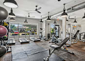 Thumbnail 17 of 32 - A gym with a variety of equipment including treadmills, weights, and exercise machines.