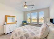 Thumbnail 19 of 44 - a bedroom with a large bed and a ceiling fan