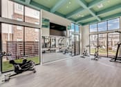 Thumbnail 27 of 30 - A spacious gym with a variety of equipment including treadmills, stationary bikes, and weight machines.