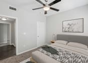 Thumbnail 31 of 70 - A bedroom with a bed, a ceiling fan, and a painting on the wall.
