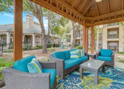 Thumbnail 34 of 44 - a covered patio with couches and chairs and a table