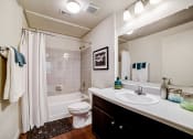 Thumbnail 14 of 42 - a bathroom with a white sink and toilet next to a bathtub with a shower curtain