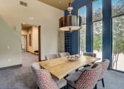 Thumbnail 18 of 50 - a dining room with a wooden table and chairs and large windows