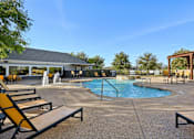 Thumbnail 60 of 70 - A pool area with a fountain and lounge chairs.