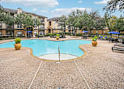 Thumbnail 23 of 27 - A large swimming pool surrounded by a concrete patio and trees.