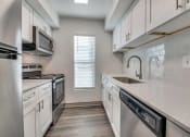 Thumbnail 4 of 21 - an empty kitchen with white cabinets and a sink