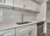 Thumbnail 3 of 21 - an empty kitchen with white cabinets and a sink
