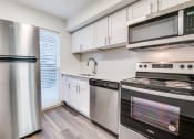 Thumbnail 2 of 21 - a kitchen with stainless steel appliances and white cabinets
