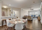Thumbnail 8 of 48 - a dining area with a table and chairs and a living room in the background