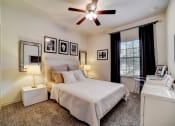 Thumbnail 12 of 42 - a bedroom with a large bed and a ceiling fan