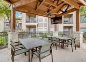 Thumbnail 35 of 44 - a patio with tables and chairs and a wooden gazebo with a television