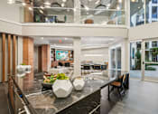 Thumbnail 20 of 31 - A modern kitchen with a marble countertop and a glass balcony.