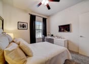 Thumbnail 13 of 42 - a bedroom with a large bed and a ceiling fan