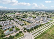 Thumbnail 67 of 70 - A suburban neighborhood with apartment buildings and a road with a median.