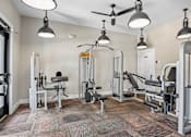 Thumbnail 15 of 32 - A gym with a variety of equipment including a bench press, a squat rack, and a leg press machine.