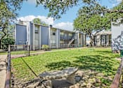 Thumbnail 41 of 47 - A modern building with a fence and a green lawn in front.