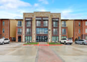 Thumbnail 37 of 44 - a brick building with cars parked in front of it