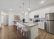 Thumbnail 1 of 43 - A kitchen with a bar area and stools.