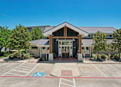 Thumbnail 21 of 55 - A building with a parking lot in front of it.