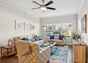 Thumbnail 6 of 70 - A living room with a couch, chair, and a fan.