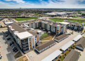 Thumbnail 39 of 44 - an aerial view of an apartment complex with cars parked in a parking lot
