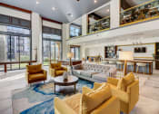 Thumbnail 25 of 44 - a living room with couches and chairs and a kitchen with large windows