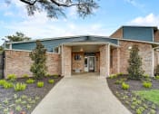 Thumbnail 17 of 27 - the front of a brick building with a walkway and plants