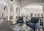 Thumbnail 22 of 45 - A spacious lobby with two chairs and a patterned rug.