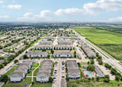 Thumbnail 65 of 70 - A bird's eye view of a residential area with multiple houses and a swimming pool.