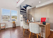 Thumbnail 16 of 35 - A room with a desk, chairs and a staircase.