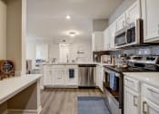 Thumbnail 4 of 48 - a kitchen with white cabinets and stainless steel appliances