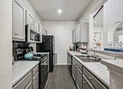 Thumbnail 23 of 45 - A kitchen with black appliances and white cabinets.