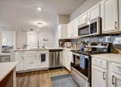 Thumbnail 5 of 48 - a kitchen with white cabinets and stainless steel appliances