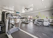 Thumbnail 27 of 45 - A gym with treadmills, elliptical machines, and other exercise equipment.