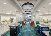Thumbnail 23 of 31 - A modern office space with a blue carpet and various seating arrangements.
