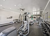 Thumbnail 28 of 45 - A spacious gym with treadmills, elliptical machines, and other exercise equipment.