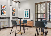 Thumbnail 23 of 28 - a bar area with stools and tables and artwork on the wall