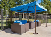 Thumbnail 17 of 28 - a blue umbrella and three couches in front of a fence