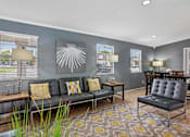 Thumbnail 12 of 26 - A living room with a grey couch and a yellow pillow.