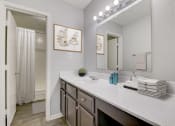 Thumbnail 8 of 23 - a bathroom with a sink and a mirror and a shower
