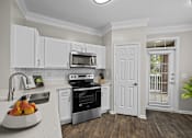 Thumbnail 4 of 52 - a kitchen with white cabinets and black appliances and a sink
