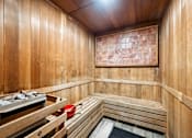 Thumbnail 31 of 44 - A wooden sauna with benches and a bucket of stones.