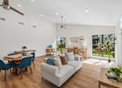 Thumbnail 11 of 33 - A living room with a couch, chairs, and a dining table.