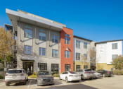 Thumbnail 21 of 37 - an apartment building with cars parked in front of it