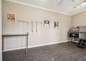 Thumbnail 30 of 45 - A room with a white ceiling, a grey floor, and a white wall with a picture hanging on it.
